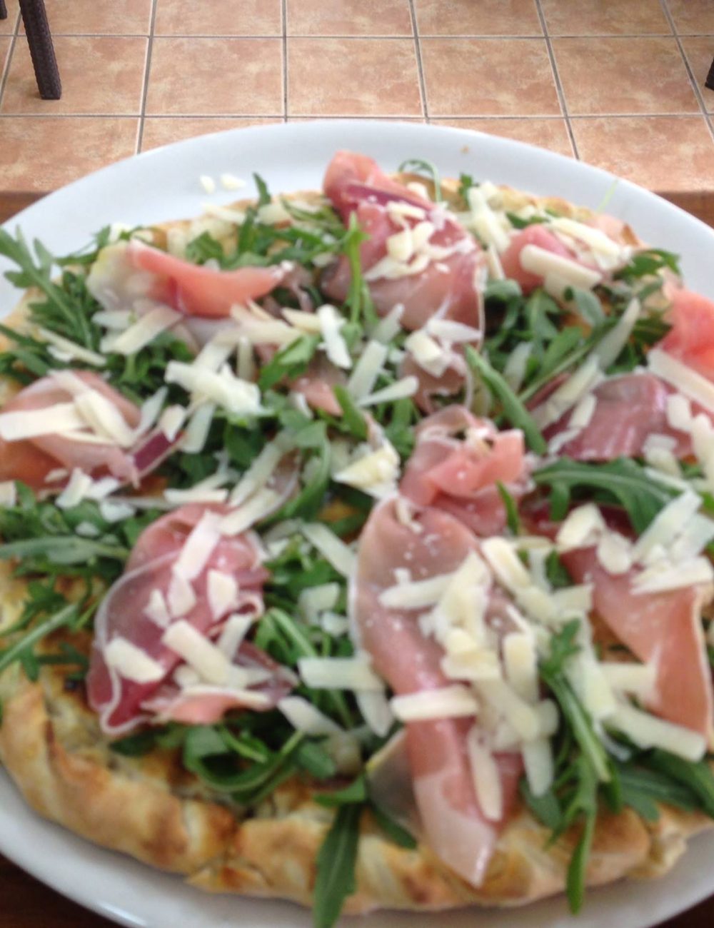Pizza con jamón serrano y rúcula servida en una pizzería italiana en Fuengirola
